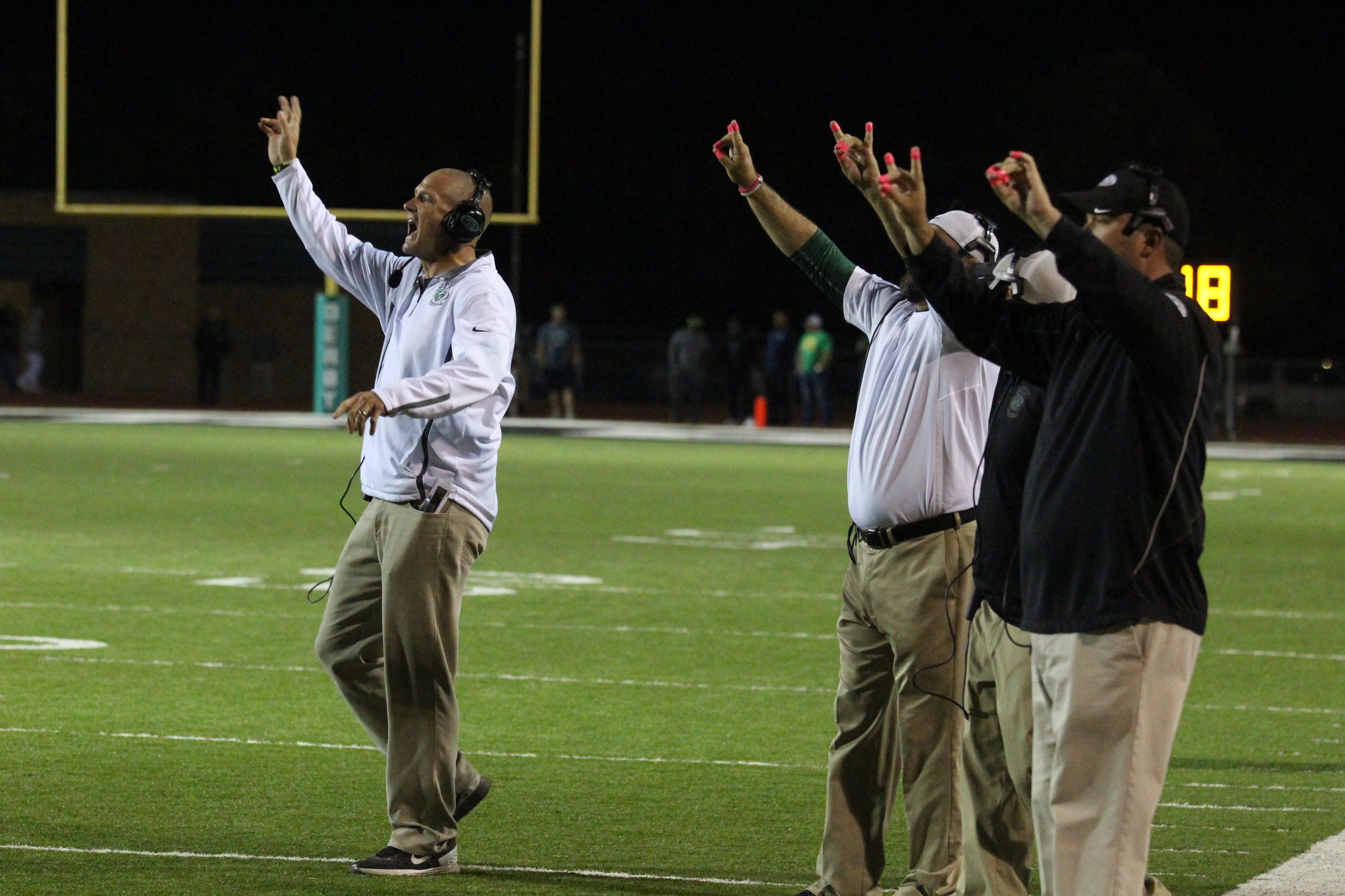 Coaches from the sideline call a play